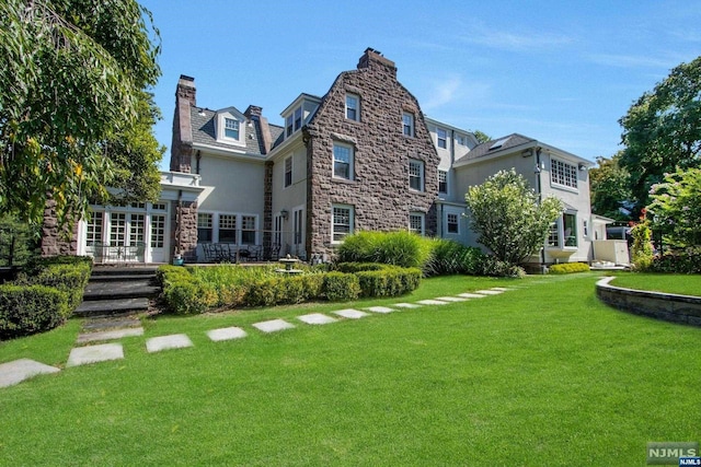 rear view of property featuring a lawn