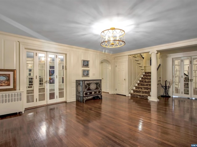 interior space with an inviting chandelier, french doors, dark hardwood / wood-style floors, ornamental molding, and radiator heating unit