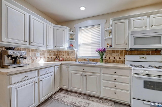 kitchen featuring white cabinets, decorative backsplash, white appliances, and sink