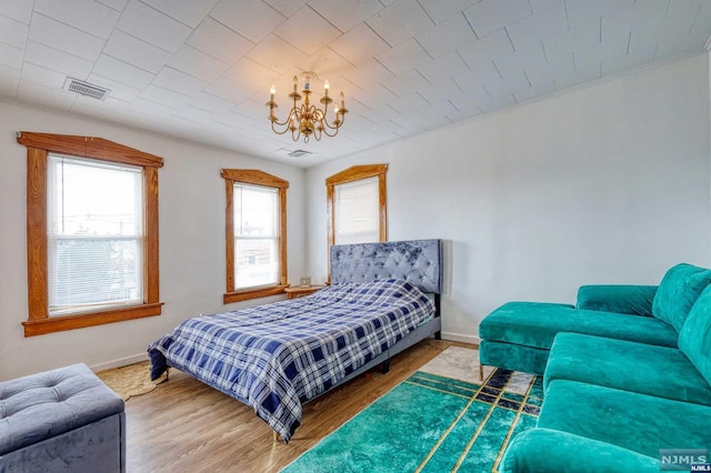 bedroom featuring hardwood / wood-style floors and a notable chandelier