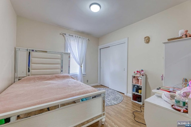 bedroom featuring light wood-type flooring and a closet