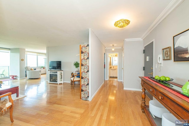 hall featuring light wood-type flooring and crown molding