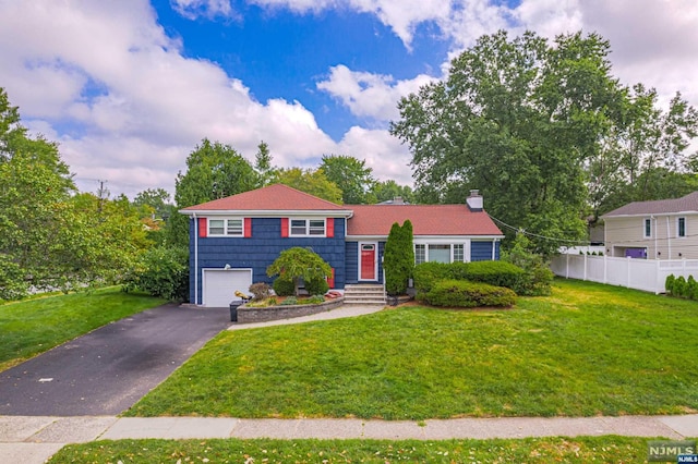 view of front of property featuring a front lawn and a garage