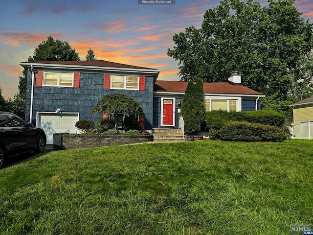 view of front of house with a garage and a yard