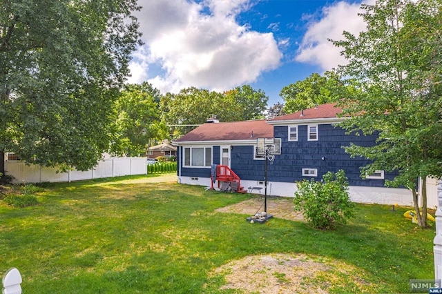 rear view of property featuring a yard