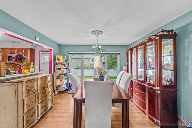 dining space featuring an inviting chandelier and light wood-type flooring