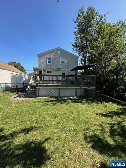 rear view of property with a lawn and a deck