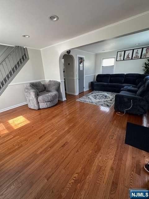 living room featuring crown molding and hardwood / wood-style flooring