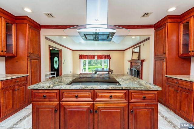 kitchen featuring light stone countertops, black electric cooktop, and crown molding