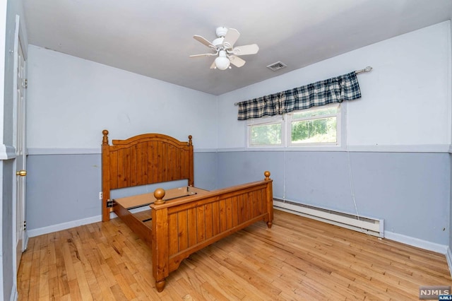 bedroom with baseboard heating, ceiling fan, and light hardwood / wood-style flooring