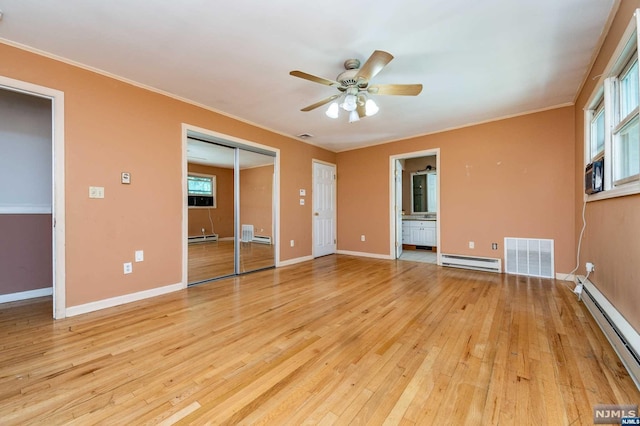 unfurnished room with light hardwood / wood-style floors, baseboard heating, and crown molding