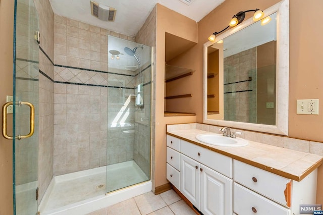 bathroom with vanity, tile patterned floors, and a shower with door