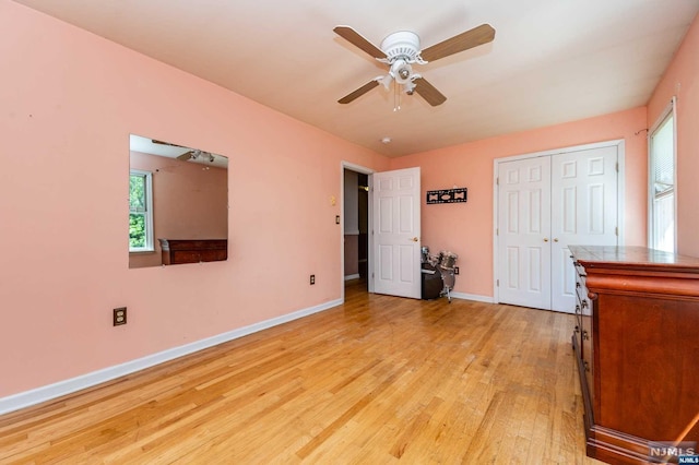 unfurnished bedroom featuring ceiling fan, light hardwood / wood-style floors, and a closet