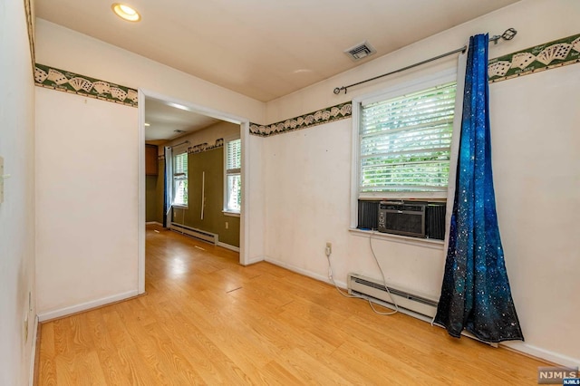 spare room with plenty of natural light, light hardwood / wood-style floors, and a baseboard radiator