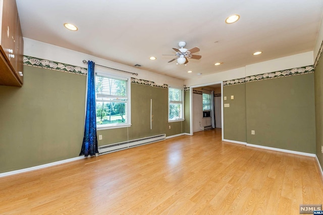 unfurnished room with ceiling fan, light hardwood / wood-style floors, and a baseboard heating unit