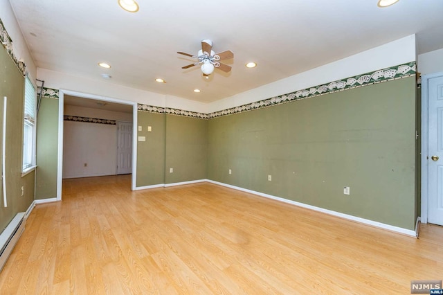 spare room with ceiling fan, light hardwood / wood-style flooring, and a baseboard heating unit