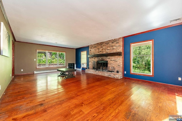 unfurnished living room featuring ornamental molding, wood-type flooring, baseboard heating, and a brick fireplace