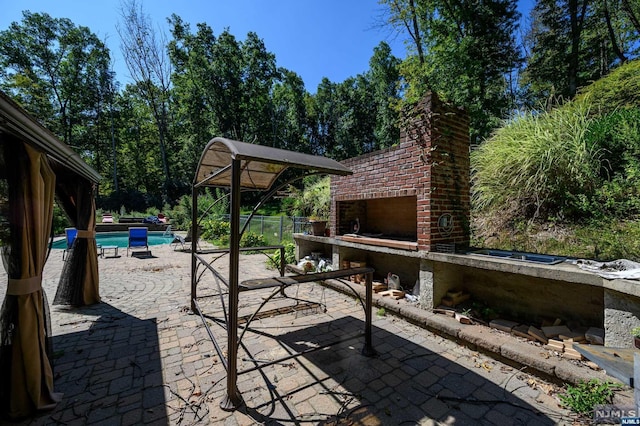 view of patio / terrace with an outdoor brick fireplace