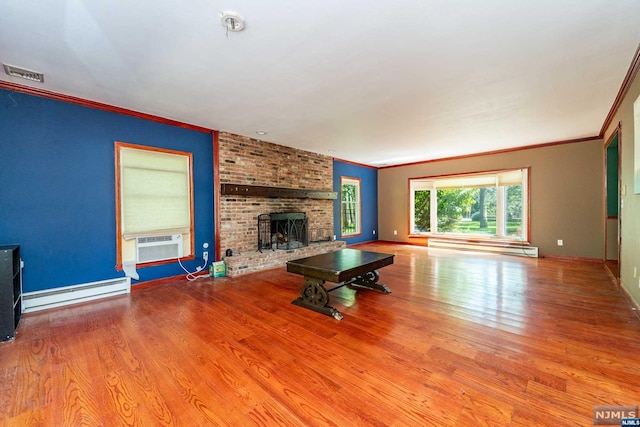 unfurnished living room with ornamental molding, a fireplace, light hardwood / wood-style floors, and a baseboard heating unit