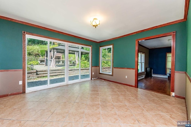 unfurnished room with baseboard heating, crown molding, and a wealth of natural light