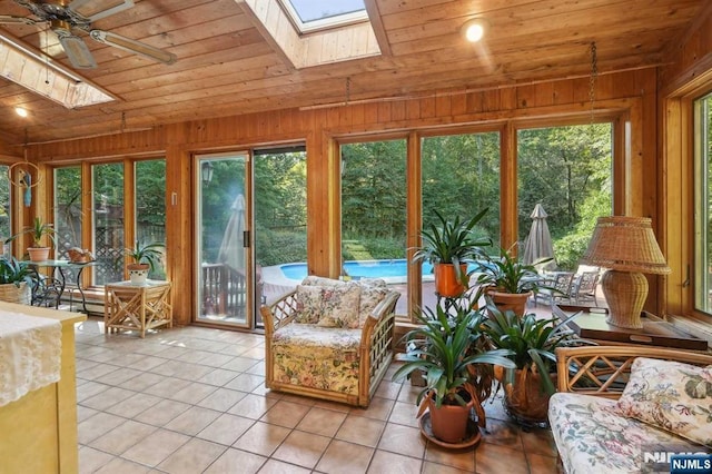 sunroom / solarium with ceiling fan, lofted ceiling with skylight, and wooden ceiling