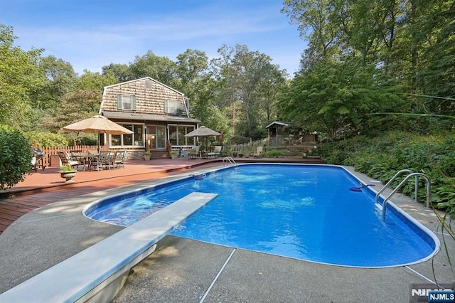 view of pool featuring a deck and a diving board