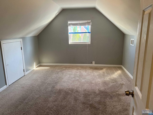 bonus room with light colored carpet and lofted ceiling