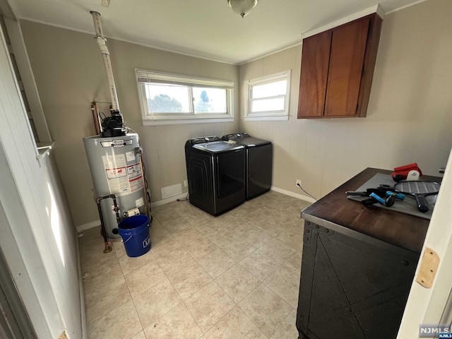 laundry room featuring washing machine and clothes dryer, cabinets, and gas water heater