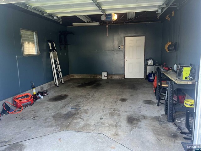 garage with a workshop area and a garage door opener