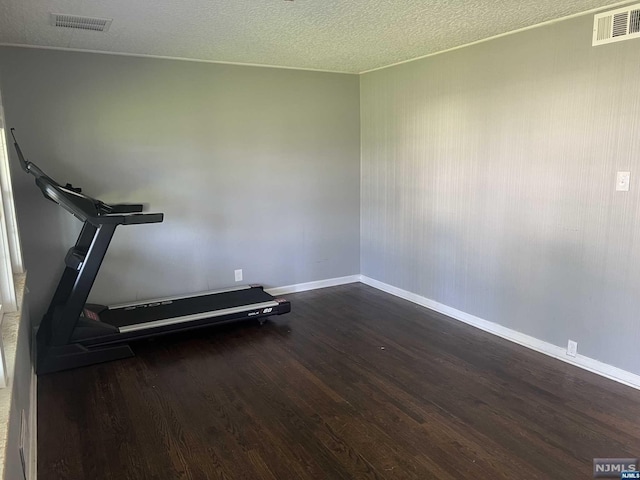 exercise area with a textured ceiling and dark hardwood / wood-style flooring