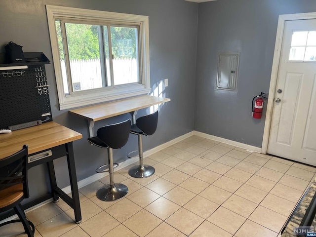 interior space featuring light tile patterned floors, electric panel, and a healthy amount of sunlight