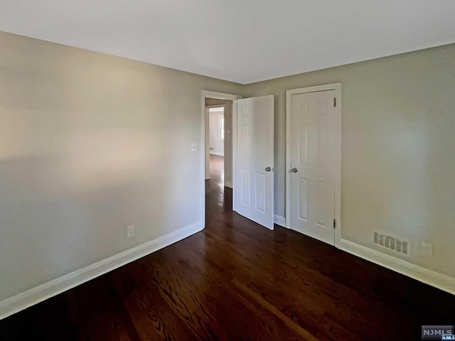unfurnished bedroom with dark hardwood / wood-style floors