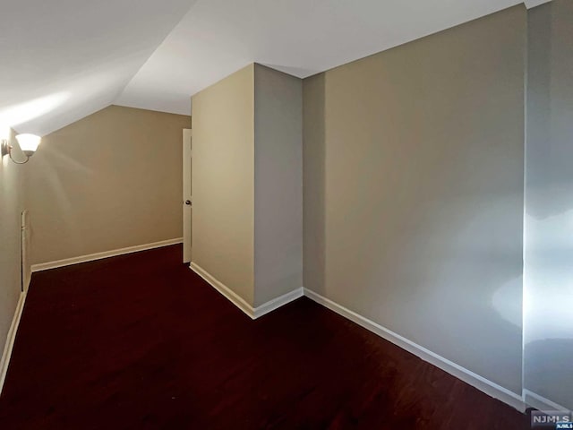 bonus room with dark hardwood / wood-style flooring and lofted ceiling