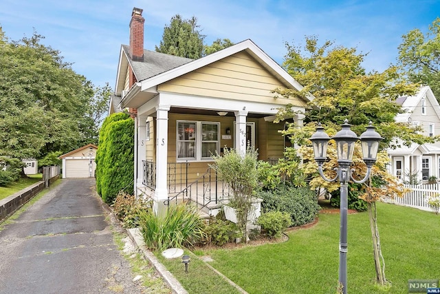 view of front of property with an outbuilding, a garage, and a front lawn