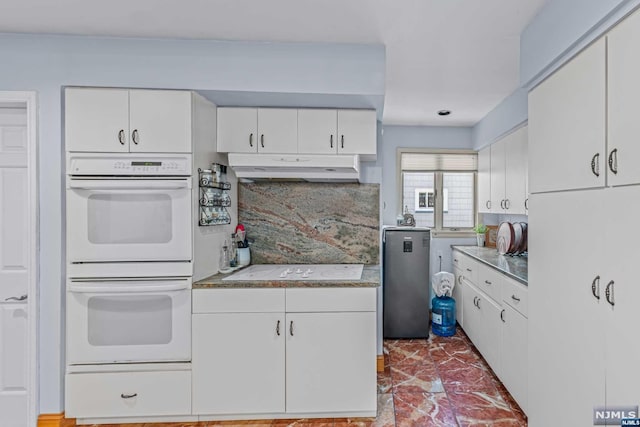 kitchen featuring white cabinets, decorative backsplash, and white appliances