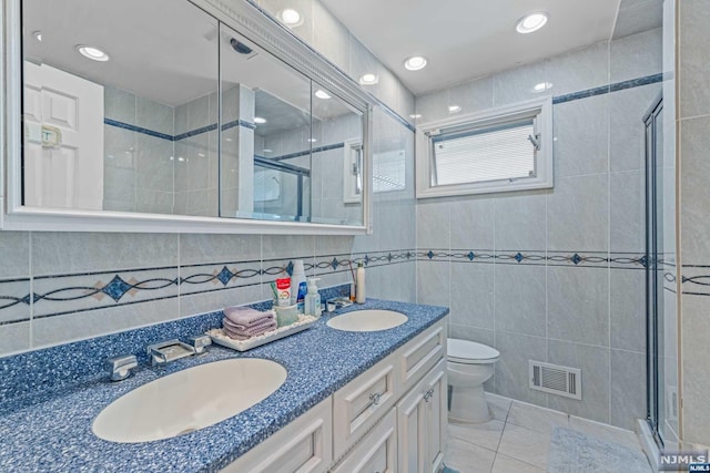 bathroom featuring tile patterned floors, toilet, tile walls, and walk in shower