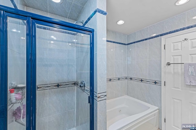 bathroom with plus walk in shower and tile walls