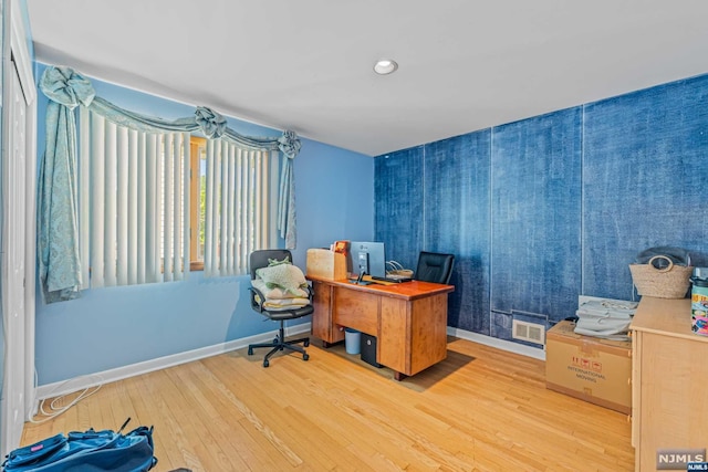 home office with light hardwood / wood-style floors