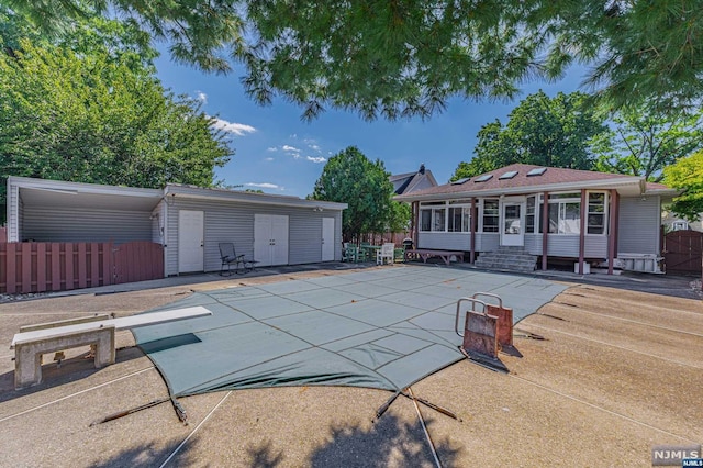 view of pool with a diving board and a patio