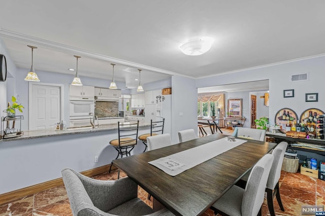 dining room with ornamental molding and sink