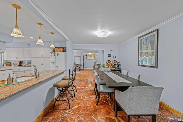 dining room with sink and ornamental molding