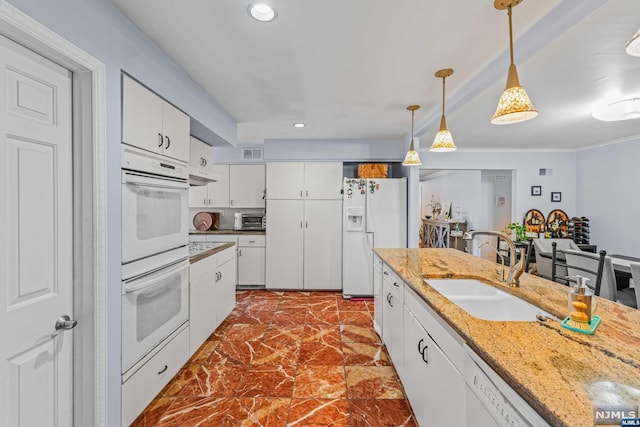 kitchen featuring white cabinets, white appliances, hanging light fixtures, and sink