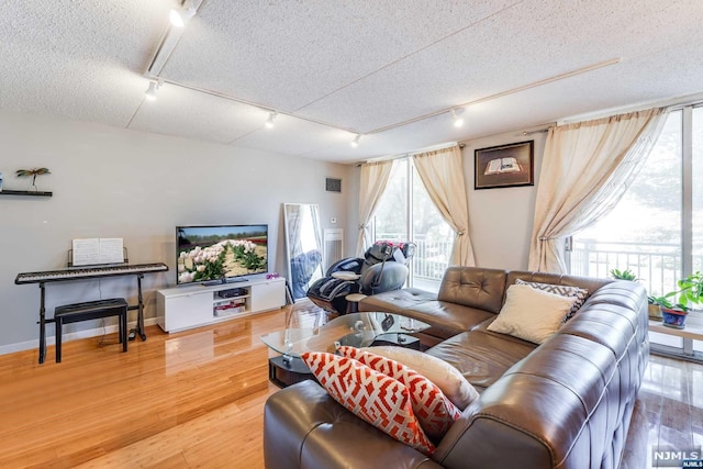 living room with hardwood / wood-style floors, rail lighting, and a textured ceiling