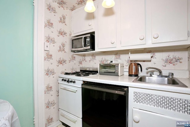 kitchen with dishwasher, white cabinets, sink, decorative light fixtures, and white range with gas stovetop