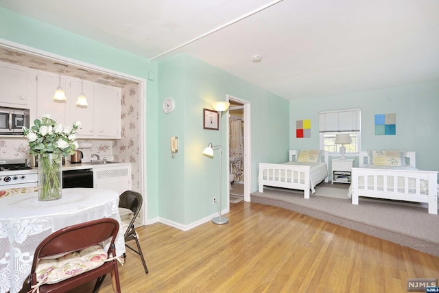 bedroom with light hardwood / wood-style floors and sink