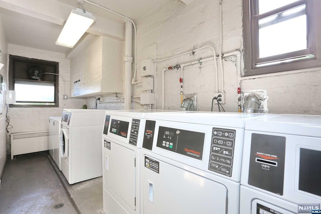 clothes washing area with washer and clothes dryer and a healthy amount of sunlight