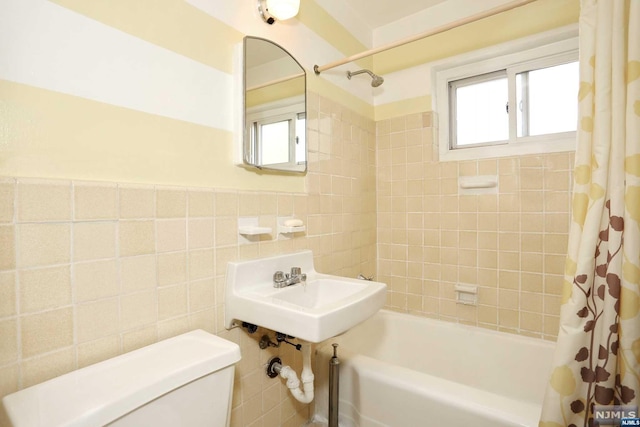 bathroom featuring shower / bath combo with shower curtain, tile walls, and toilet