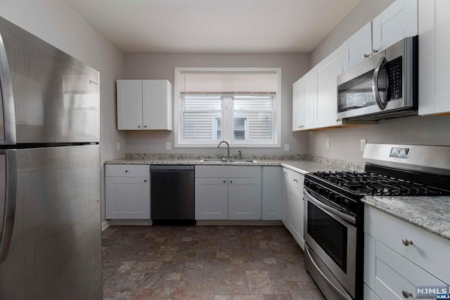 kitchen with white cabinets, appliances with stainless steel finishes, and sink