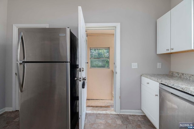 kitchen with light stone countertops, white cabinets, and appliances with stainless steel finishes