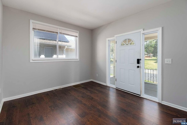 entryway with a healthy amount of sunlight and dark hardwood / wood-style floors